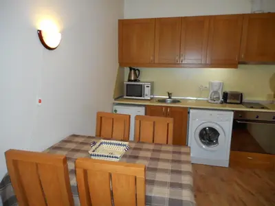 a kitchen with a table and chairs and a microwave at TES Royal Plaza Apartments in Borovets