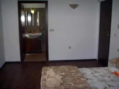 a bedroom with a bed and a bathroom with a sink at The Lake Villa in Smolyan
