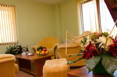 a living room with a vase of flowers on a table at Семеен хотел Кристал in Smolyan