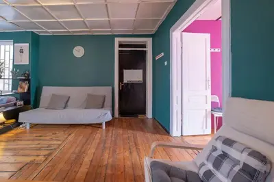 a living room with a white couch and a green wall at Cool Central Apartment in Sofia