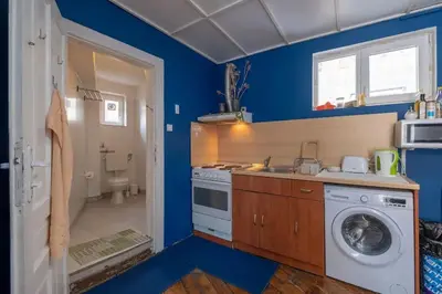 a blue kitchen with a washing machine and a sink at Cool Central Apartment in Sofia