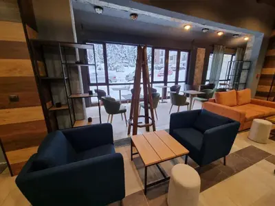 a living room with chairs and a table and a couch at Borovets Gardens Apartments in Borovets