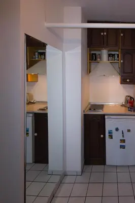 a kitchen with brown cabinets and white appliances at Mini Apartment Best Rest in Plovdiv