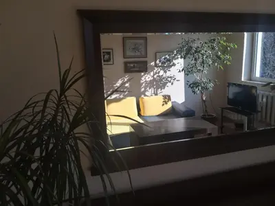 a mirror reflecting a living room with a couch and a tv at Maritza Apartment in Plovdiv