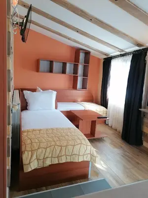 a bedroom with a bed with an orange wall at Boutique Guest House IKONOMOV in Bansko