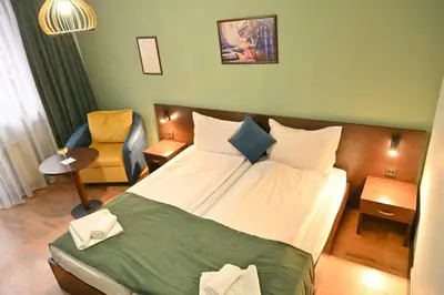 a hotel room with a bed and a chair at Hotel Ida in Bansko
