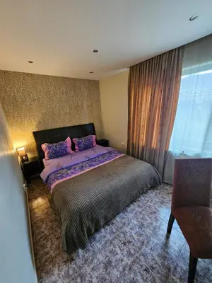 a bedroom with a bed and a chair and a window at Libera in Sofia