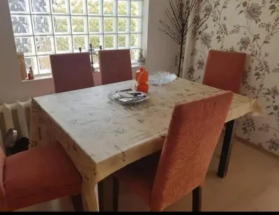 a dining room table with chairs and a wooden table with at Libera in Sofia
