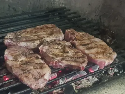 four pieces of meat cooking on a grill at Libera in Sofia