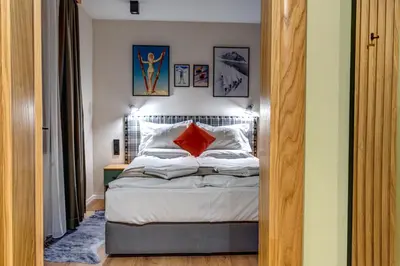a bedroom with a bed with a red pillow on it at Mountain Lake Hotel in Smolyan