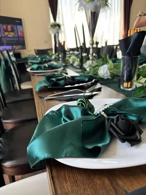 a table with a plate with green napkins on it at Vakarel Residence in Vakarel