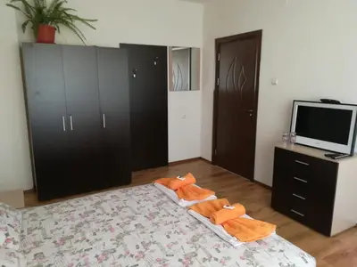 a bedroom with a bed with a tv and a dresser at Guest House Ganovi in Kalofer