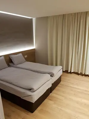 two beds sitting in a room with a window at Mihaylova kushta in Lyubosh