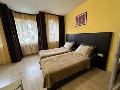 a bedroom with two beds and two windows at Apartments & Rooms Royal Plaza in Borovets