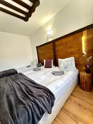 a bedroom with a large bed with a wooden headboard at Red House Family house in Bansko