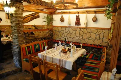 a dining room with a table and chairs in a restaurant at Balkanski chanove in Botevgrad