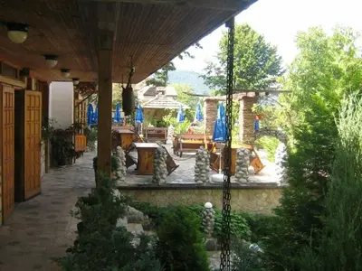 a patio with blue umbrellas on a building at Balkanski chanove in Botevgrad