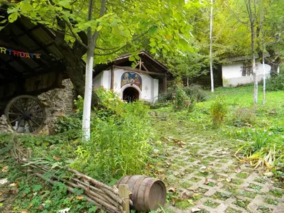 an old house with a barrel in front of it at Balkanski chanove in Botevgrad