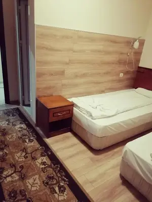 a small bedroom with a bed and a night stand at Guest House Nani in Asenovgrad