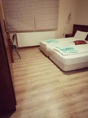 a bedroom with two beds and a wooden floor at Guest House Nani in Asenovgrad