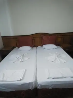two beds with white sheets and pillows on them at Guest House Nani in Asenovgrad