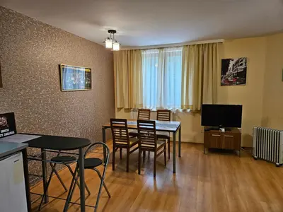 a dining room with a table and chairs and a television at Enjoy Studios and Lovely Apartment Villa Park in Borovets