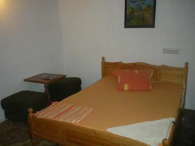 a bedroom with a wooden bed with a red pillow at Hotel- Restaurant Struma in Stara Kresna