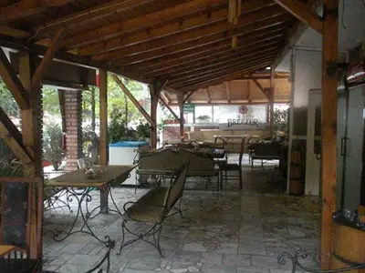 a patio with tables and chairs in a building at Hotel- Restaurant Struma in Stara Kresna