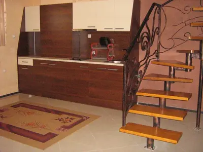 a kitchen with a counter and a staircase in a room at Family Hotel Yola in Chepelare