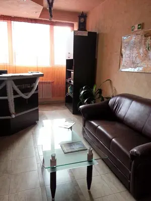a living room with a leather couch and a glass table at Family Hotel Yola in Chepelare