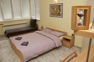a small bedroom with a bed and a chair at Hostel Mostel Sofia in Sofia