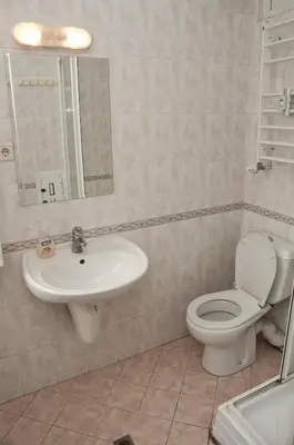 a bathroom with a sink and a toilet and a mirror at Hostel Mostel Sofia in Sofia