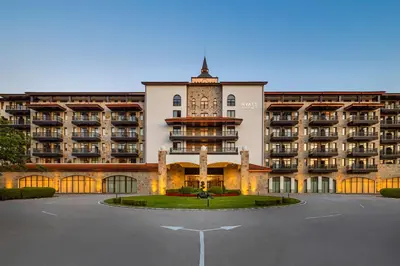 a large building with a clock tower in a parking lot at Hyatt Regency Pravets Resort in Pravets