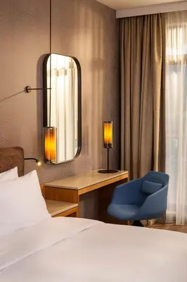 a bedroom with a bed and a chair and a mirror at Hyatt Regency Pravets Resort in Pravets