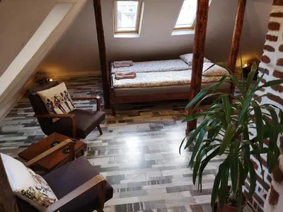 a living room with two beds and a potted plant at Gramophone Sofia Downtown Apartment in Sofia