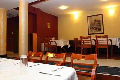 a dining room with tables and chairs in a restaurant at Fenix Family Hotel in Blagoevgrad