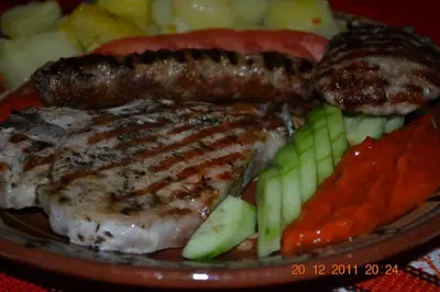 a plate of food with meat and vegetables on it at Старата Тонина къща in Dobrinishte