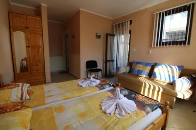 a bedroom with two beds and a couch at Старата Тонина къща in Dobrinishte