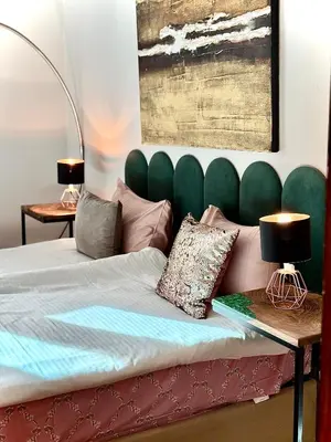a bedroom with a bed with a green headboard at City Center Stylish 3 Bedroom Apartment in Sofia