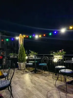 a patio with tables and chairs at night with lights at The Secret Garden in Ognyanovo