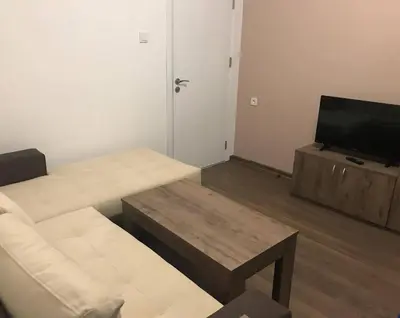 a living room with a couch and a flat screen tv at The Secret Garden in Ognyanovo