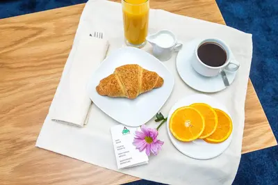 a table with a plate of toast and a cup of coffee at Park Hotel Asarel in Panagyurishte