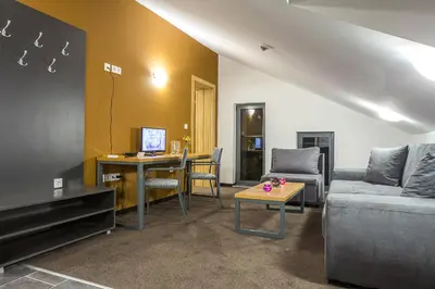 a living room with a couch and a table at Park Hotel Asarel in Panagyurishte