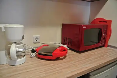 a kitchen counter with a red microwave and a mixer at Feels like Home 