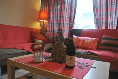 a living room with a table with two bottles of wine at Feels like Home 