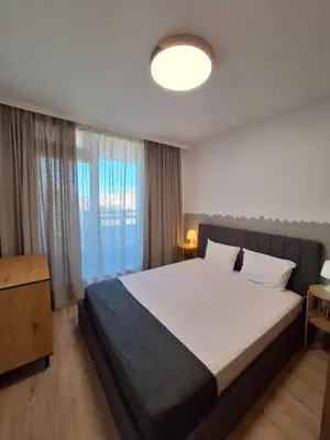 a bedroom with a bed and a large window at Apartments Mladost 1A in Sofia