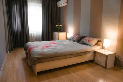 a bedroom with a bed and two night stands and a window at Sofia Central Hotel Apartments in Sofia