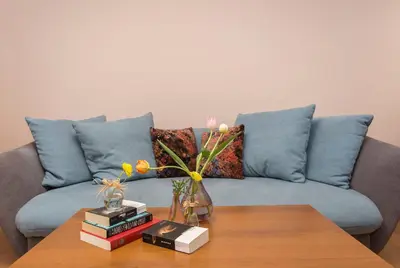 a living room with a couch and a table with books at Sofia Central Hotel Apartments in Sofia