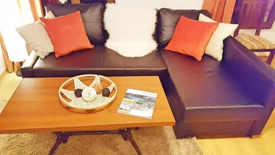 a black couch with pillows and a coffee table at Bansko front door to the Gondola and town centre in Bansko