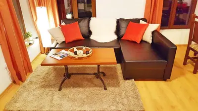 a living room with a black couch and a coffee table at Bansko front door to the Gondola and town centre in Bansko